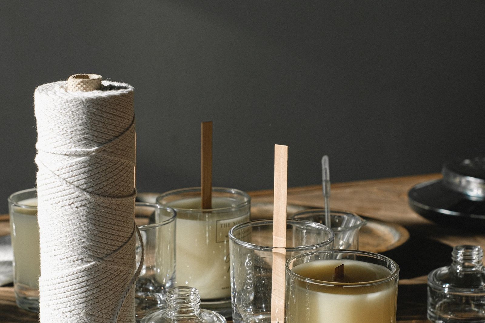 Three identical amber-glass candles burning in a row on a slate bench